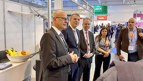 Begrüßung UN-Delegation am BDSW Stand Mehrer Menschen in einer Gesprächssituation