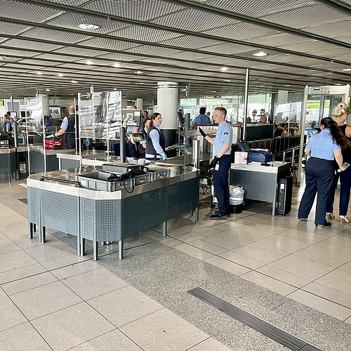Viele Menschen stehen in einer Kontrollstelle, um in den Sicherheitsbereich des Flughafens zu kommen.