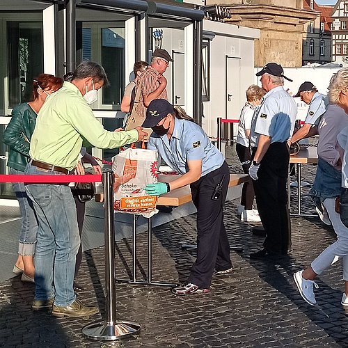 Eingangskontrolle DomStufen-Festspiele Eine Frau schaut in eine Tasche eines Paares und sucht nach gefährlichen Gegenständen.